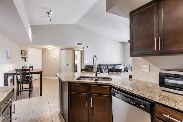 kitchen with dishwasher, sink, light stone countertops, and light tile patterned floors