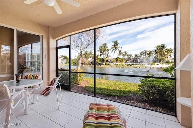 unfurnished sunroom with a water view and ceiling fan