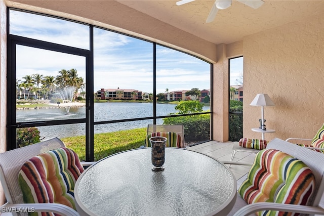 sunroom with a water view and ceiling fan