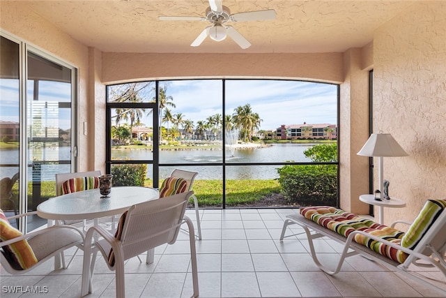 sunroom / solarium featuring a water view, ceiling fan, and a healthy amount of sunlight