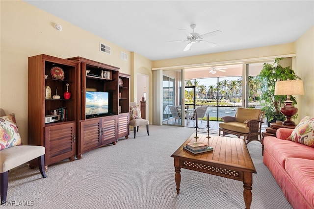 carpeted living room with ceiling fan