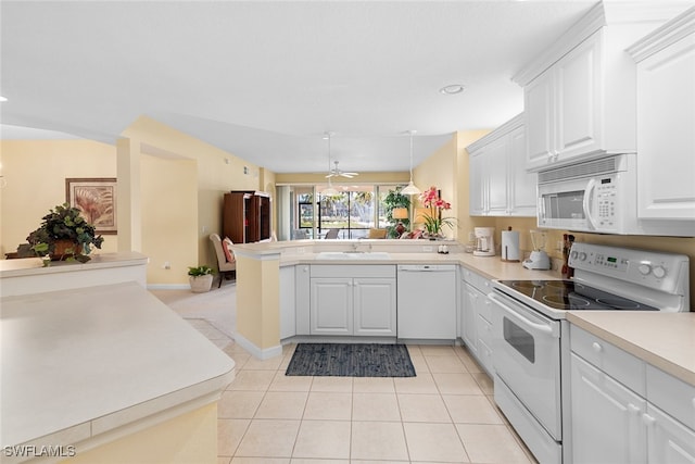 kitchen with kitchen peninsula, sink, pendant lighting, white cabinetry, and white appliances