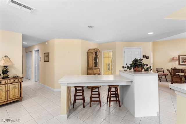 kitchen featuring a kitchen bar and light tile patterned floors