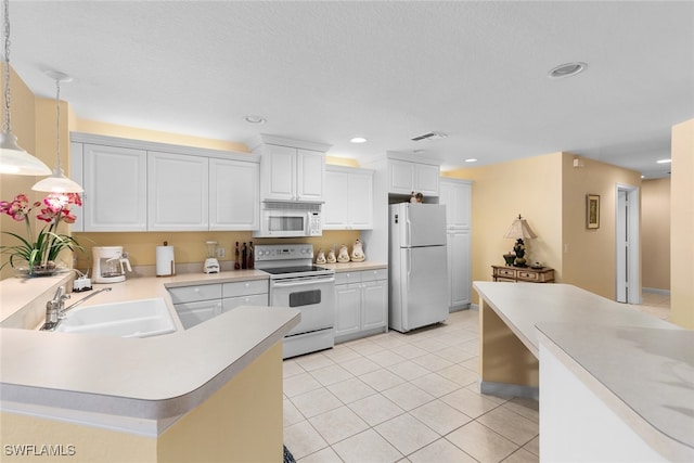 kitchen with hanging light fixtures, light tile patterned floors, white cabinetry, sink, and white appliances