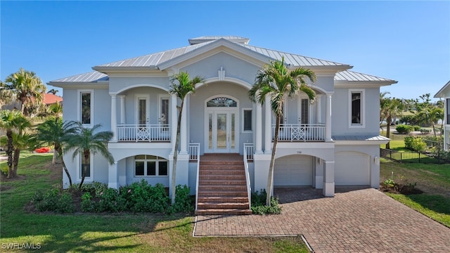 view of front of home with a garage, covered porch, and a front lawn