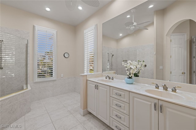 bathroom with tile patterned flooring, a tile shower, vanity, and ceiling fan