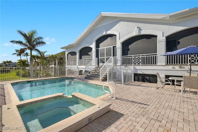 view of swimming pool featuring an in ground hot tub, a patio area, and a sunroom