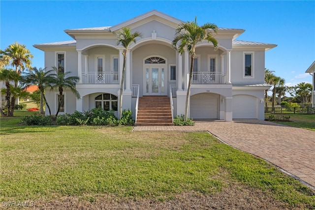 mediterranean / spanish-style home featuring a porch, a garage, and a front yard