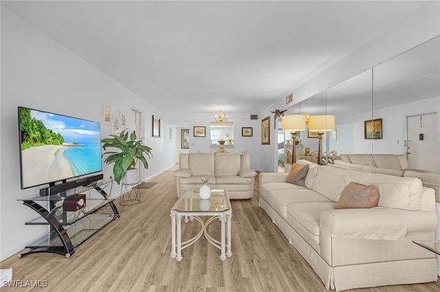 living room featuring a chandelier and light wood-type flooring