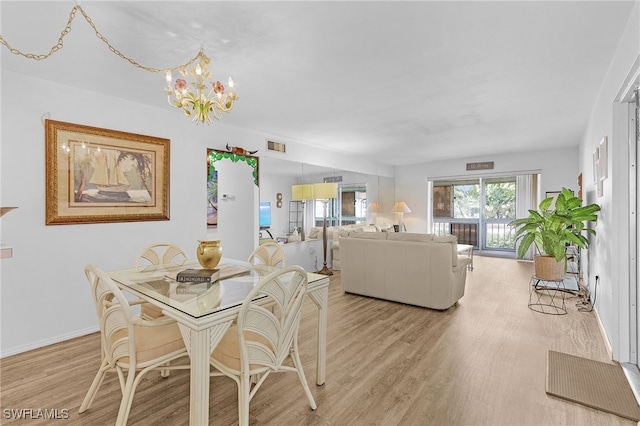 dining space with a chandelier and light wood-type flooring