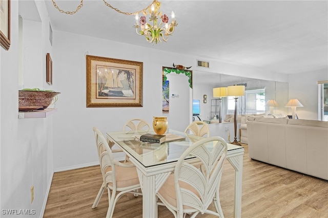 dining space with a chandelier and light hardwood / wood-style floors