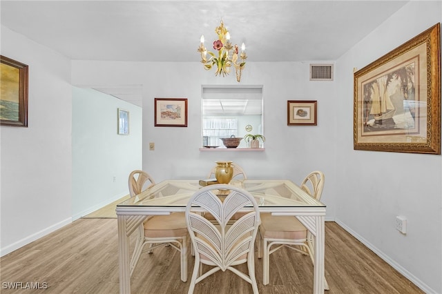 dining space featuring a chandelier and light wood-type flooring