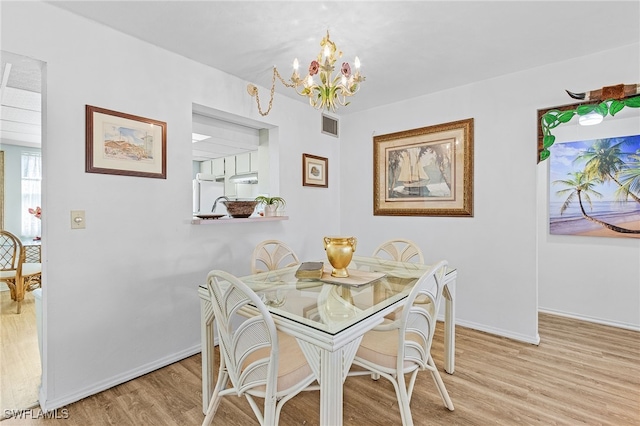 dining area featuring light hardwood / wood-style flooring and a notable chandelier