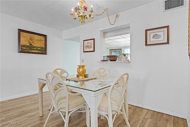 dining space with an inviting chandelier and light wood-type flooring