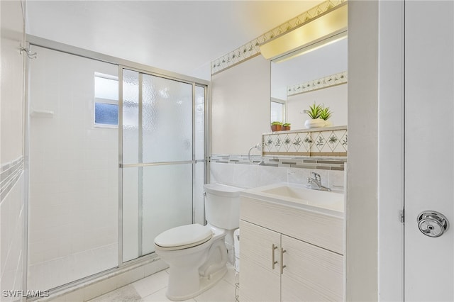 bathroom with vanity, toilet, tile walls, and a shower with shower door