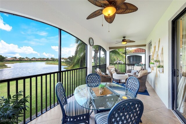 sunroom featuring a water view and ceiling fan