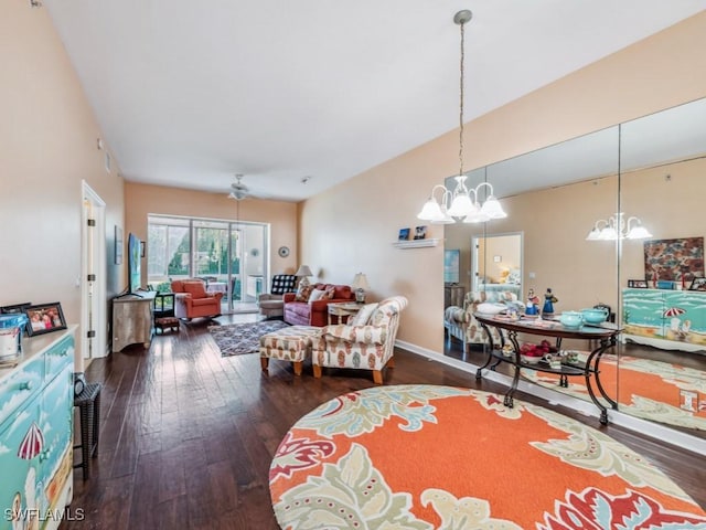 living room featuring ceiling fan with notable chandelier and dark hardwood / wood-style flooring