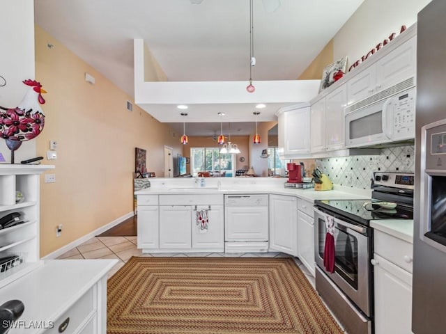 kitchen featuring kitchen peninsula, white cabinets, hanging light fixtures, and white appliances