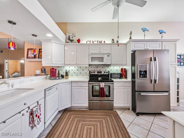 kitchen featuring white cabinets, appliances with stainless steel finishes, decorative light fixtures, and sink