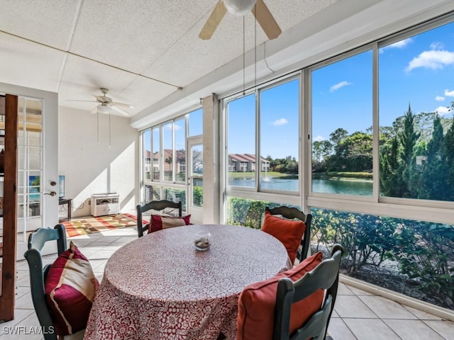 sunroom / solarium featuring a water view and ceiling fan