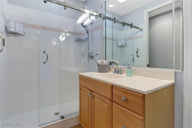 bathroom featuring vanity and a shower with door