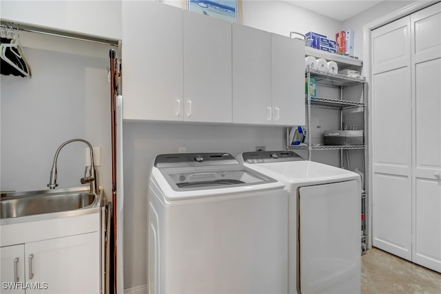 clothes washing area with cabinets, sink, and washer and clothes dryer