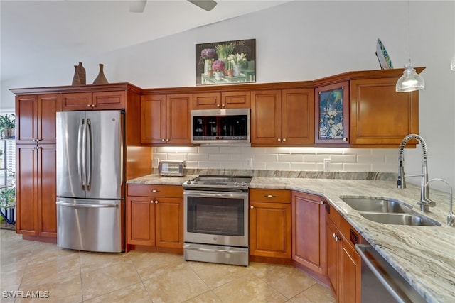 kitchen featuring hanging light fixtures, sink, vaulted ceiling, light tile patterned floors, and appliances with stainless steel finishes