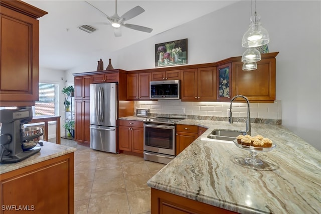 kitchen with sink, vaulted ceiling, pendant lighting, light tile patterned floors, and appliances with stainless steel finishes