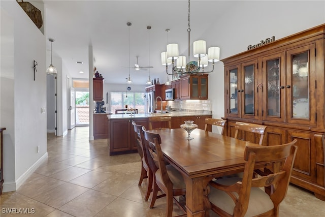 dining space featuring sink, a notable chandelier, high vaulted ceiling, and light tile patterned floors