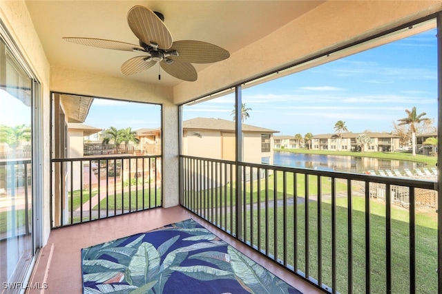 sunroom featuring a water view, ceiling fan, and plenty of natural light