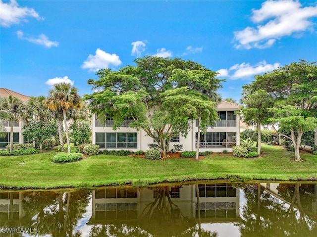 rear view of house featuring a yard and a water view