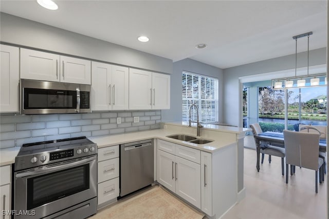 kitchen with kitchen peninsula, white cabinetry, and appliances with stainless steel finishes