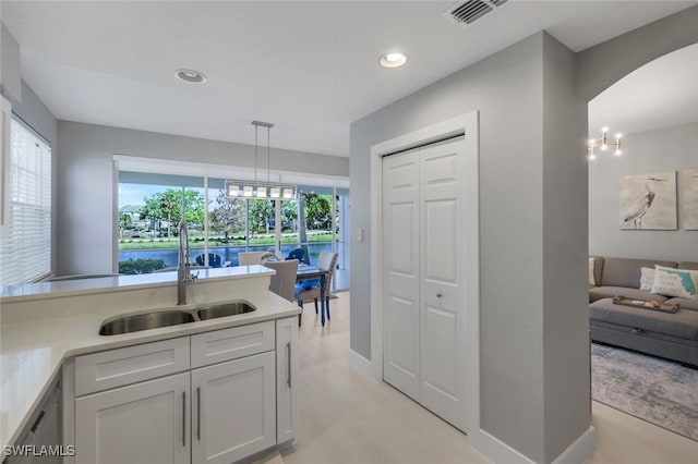 kitchen featuring dishwasher, decorative light fixtures, white cabinetry, and sink