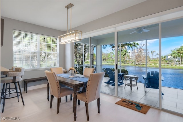 dining space featuring ceiling fan and a water view