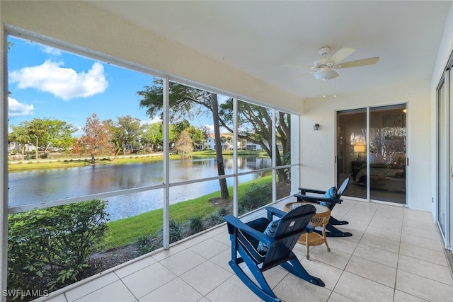 sunroom / solarium featuring ceiling fan, a water view, and a wealth of natural light