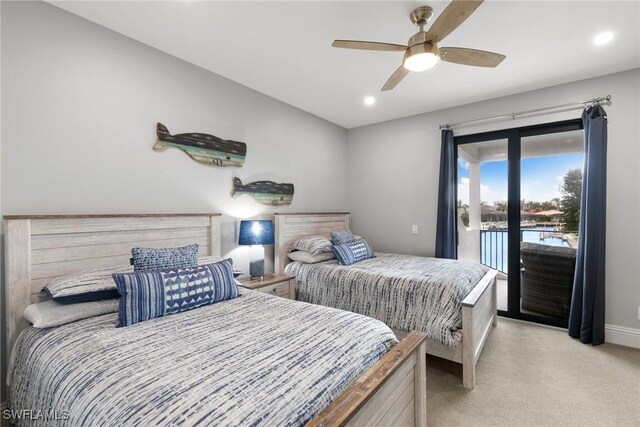 bedroom with access to exterior, light colored carpet, ceiling fan, and a water view