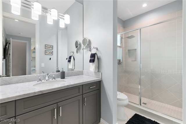 bathroom with vanity, toilet, and a shower with door