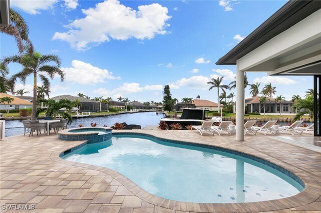 view of pool with an in ground hot tub, a patio, and a water view