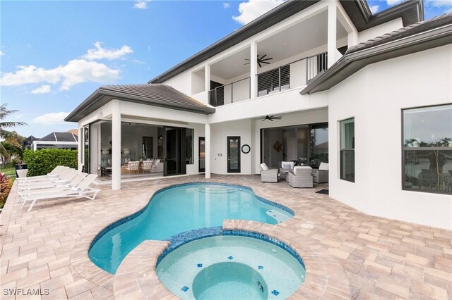 rear view of property featuring an outdoor living space, a patio area, a balcony, and ceiling fan