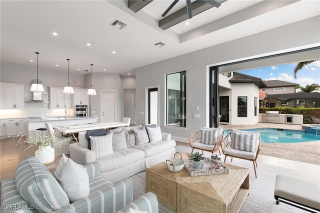 living room featuring beamed ceiling and a towering ceiling