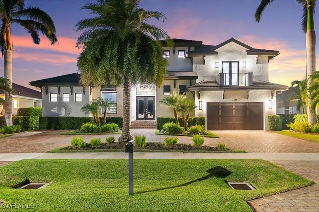 view of front of house with french doors, a yard, and a garage