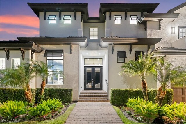 exterior entry at dusk featuring french doors