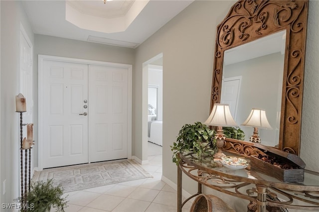 foyer entrance featuring a tray ceiling and light tile patterned flooring