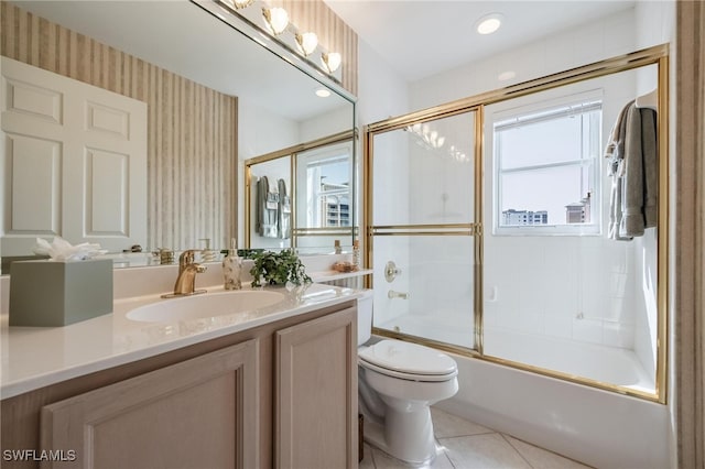 full bathroom featuring tile patterned floors, vanity, toilet, and bath / shower combo with glass door