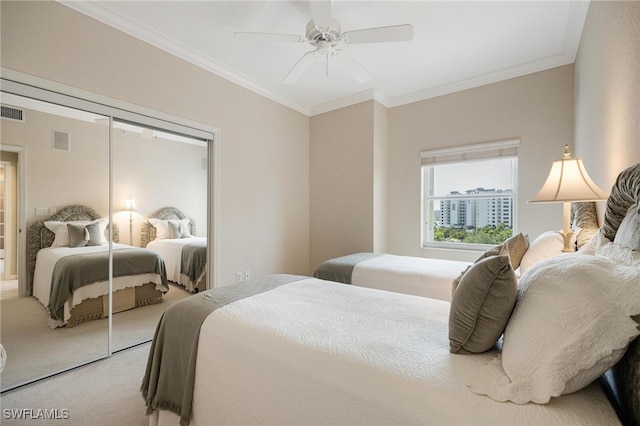 carpeted bedroom featuring ceiling fan, a closet, and ornamental molding