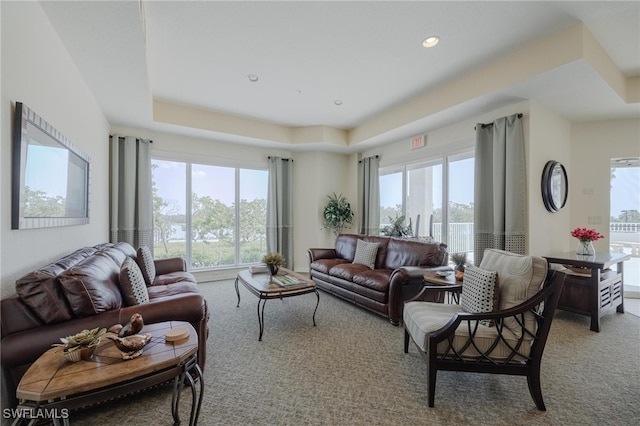 carpeted living room featuring a tray ceiling