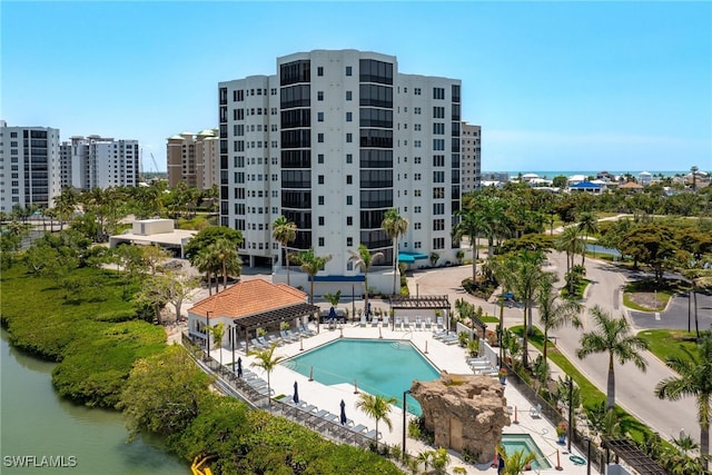 view of swimming pool featuring a patio and a water view