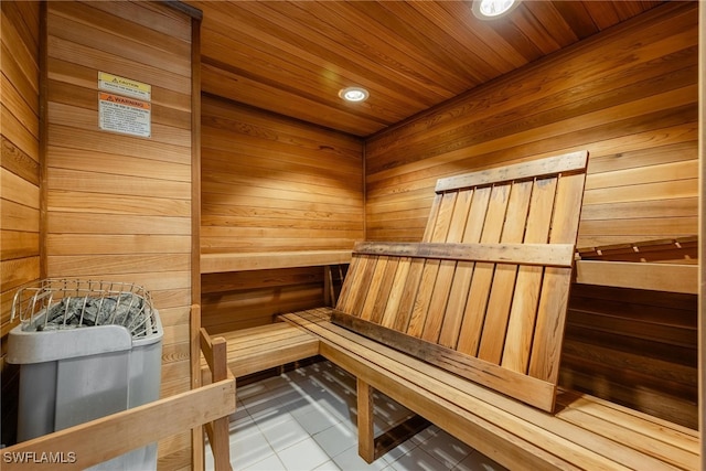 view of sauna with wooden walls, wood ceiling, and tile patterned floors