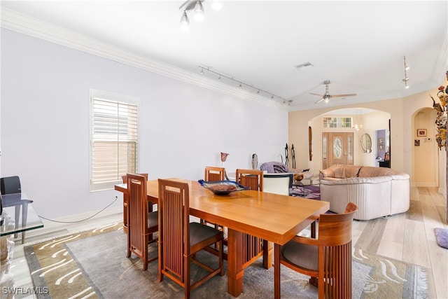 dining room with hardwood / wood-style flooring, ceiling fan, rail lighting, and crown molding