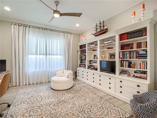 sitting room with crown molding, light hardwood / wood-style flooring, and ceiling fan